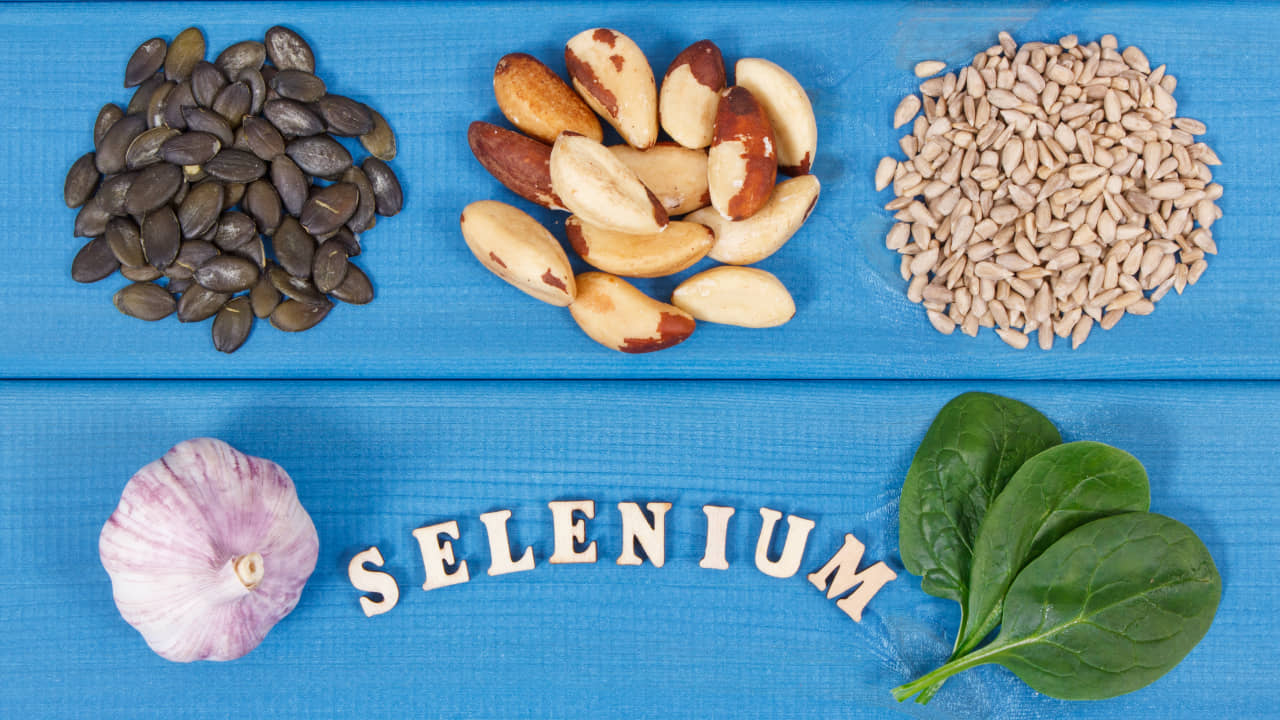 Ceviz, tohumlar ve ıspanak gibi besinlerin bulunduğu mavi alan üzerinde Selenyum yazısı