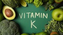yeşil sebzelerle çevrili Vitamin K yazısı